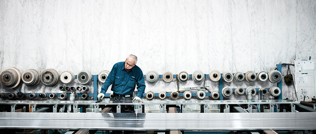 man in workshop with many different extrusion dies