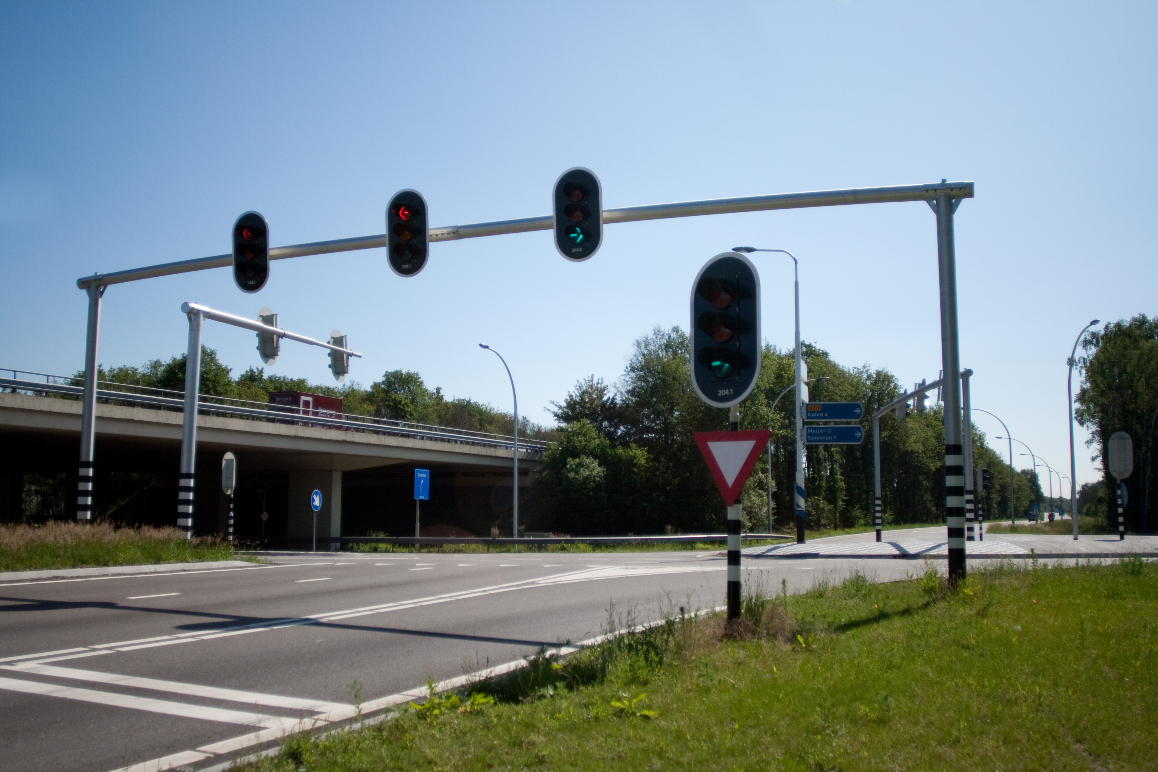 an intersection. traffic lights hanging on a pole across the road