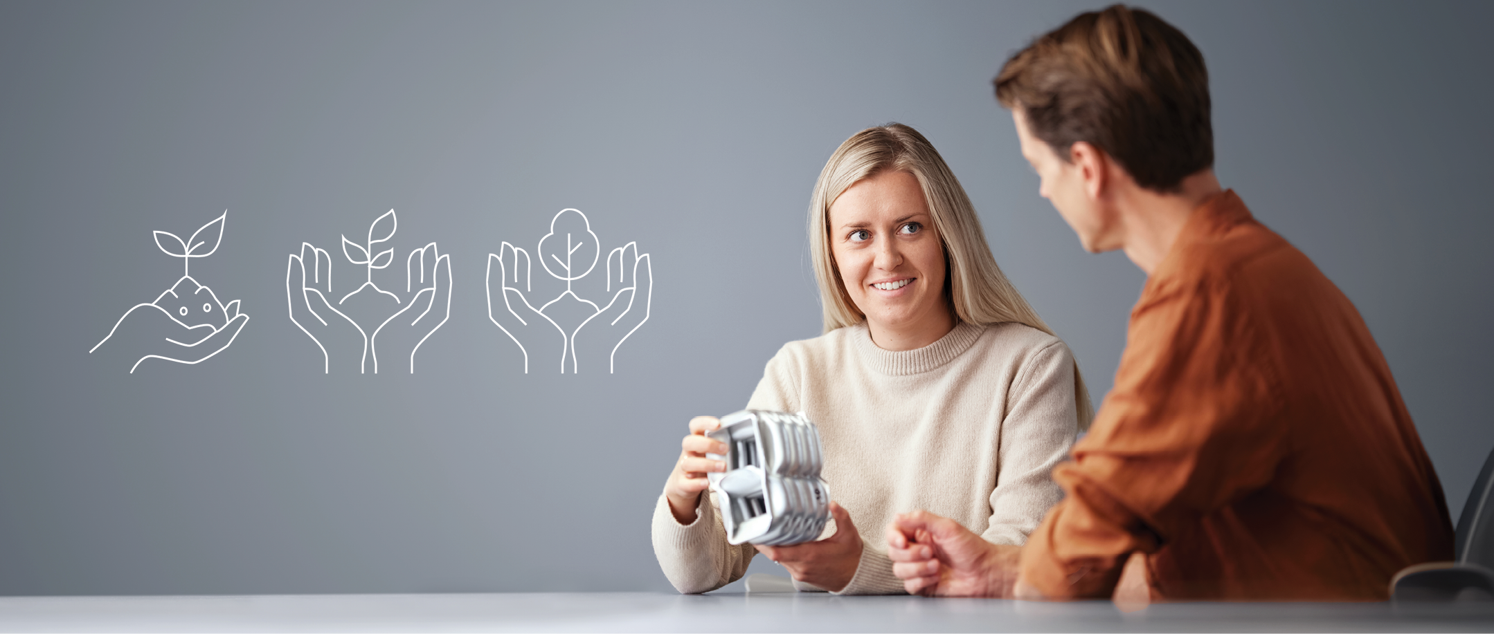Two persons sitting at the table discussing an aluminium profile