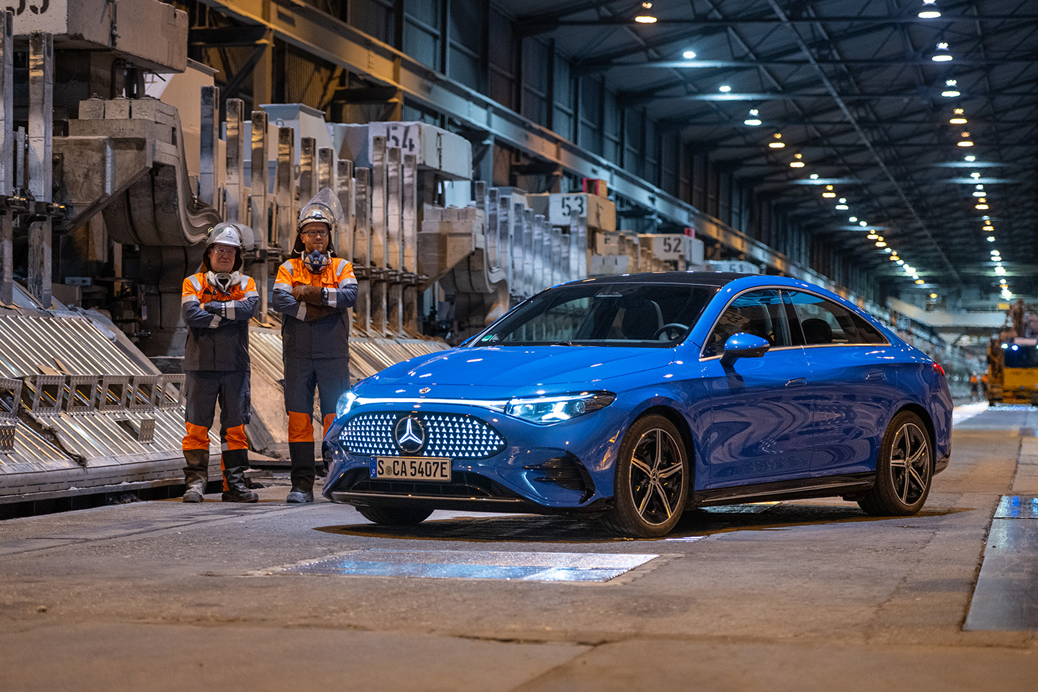a blue car with a couple of people standing next to it