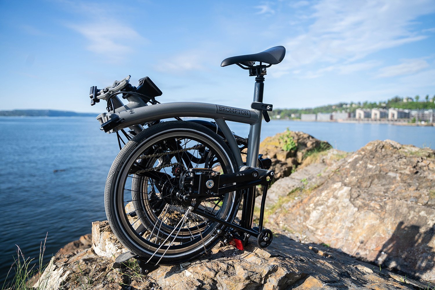 a bicycle parked on a rock by the water