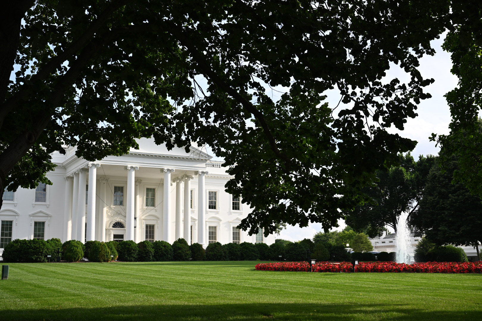 a white house with a fountain in the front