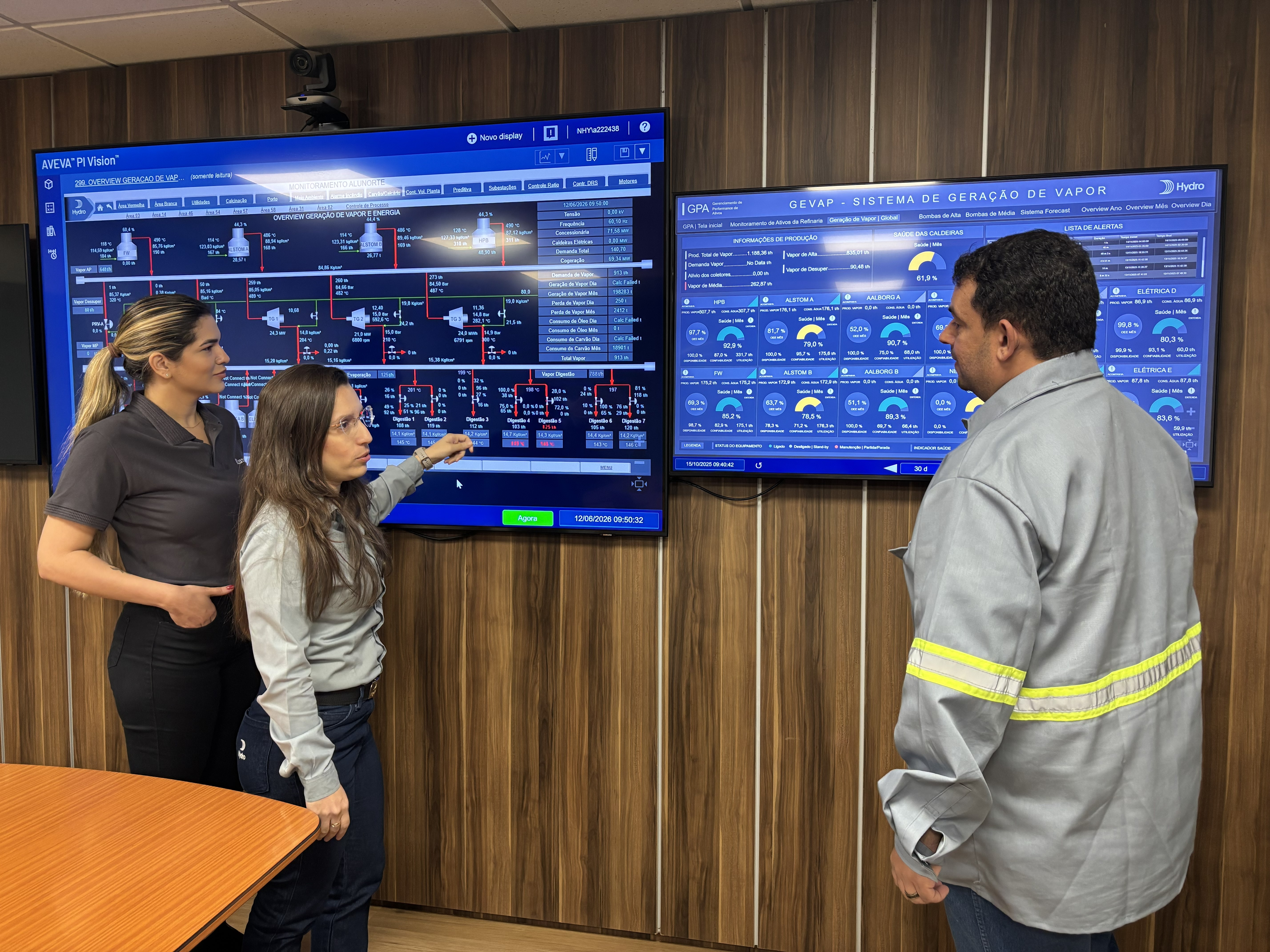 a group of people standing in front of a large screen