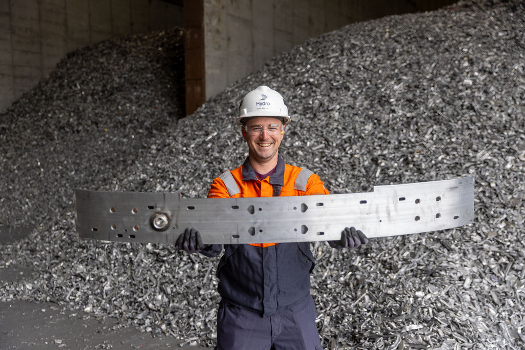 a man in a hard hat holding a large piece of metal