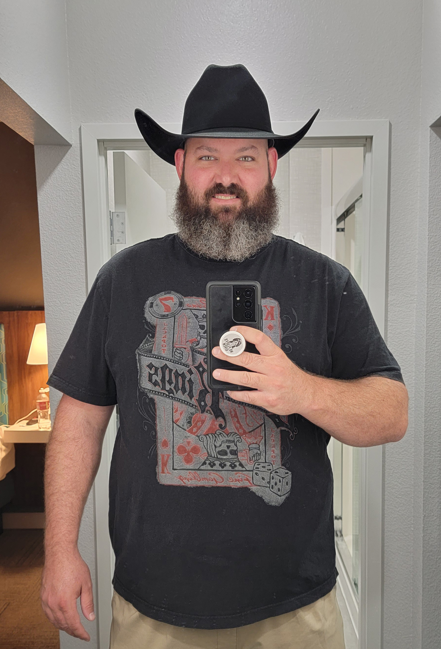 a man wearing a cowboy hat and holding a cell phone