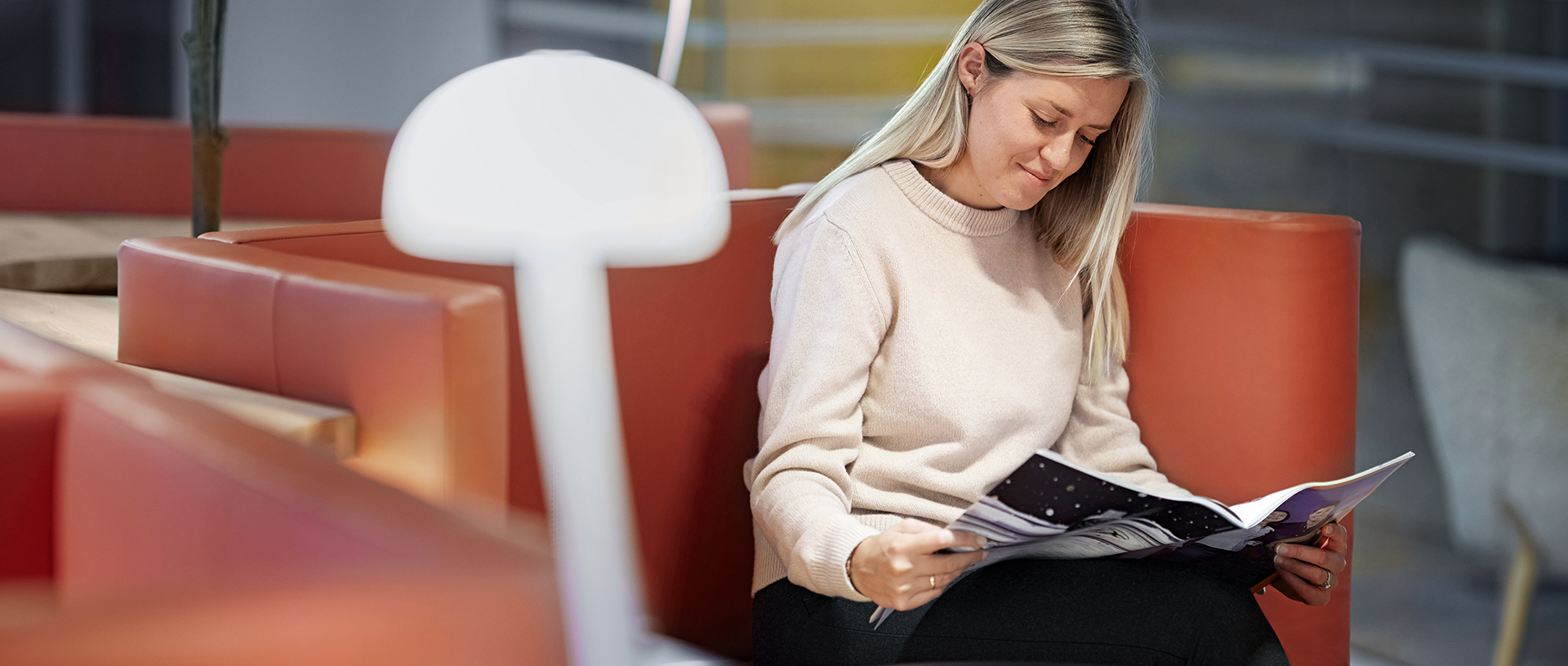 a woman sitting on a bench reading a book