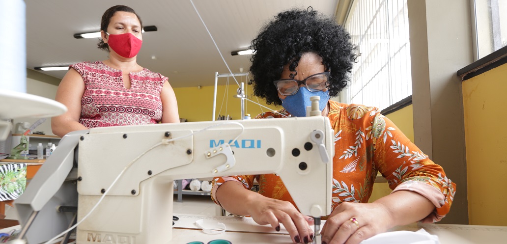 a woman and a man in a lab coat looking at a microscope