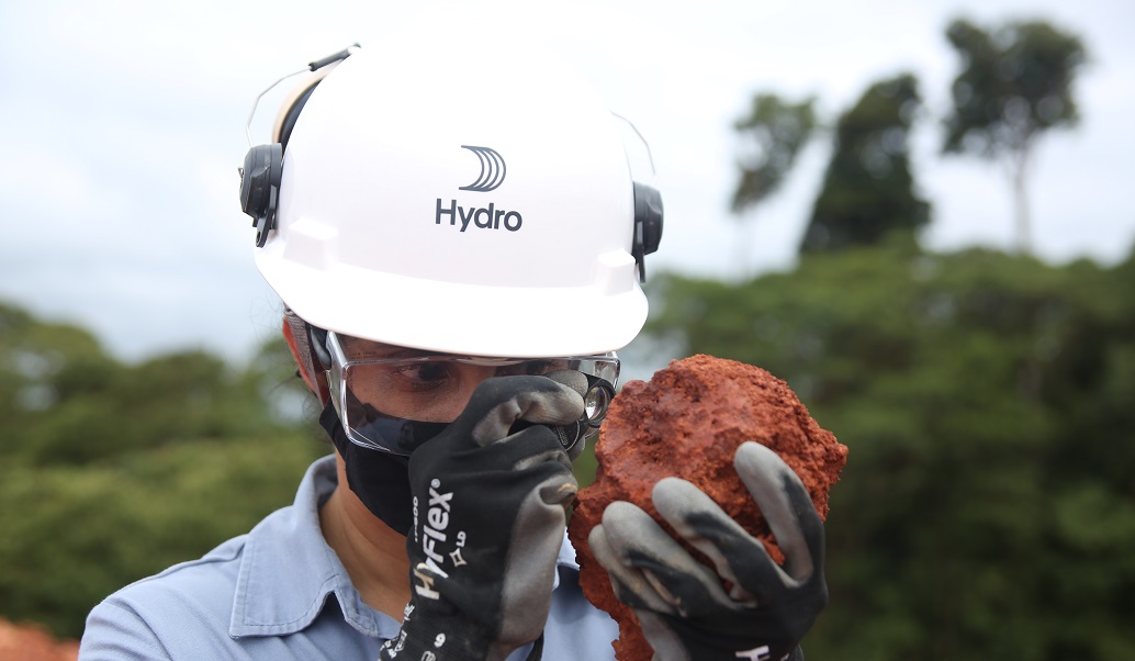 a man wearing a helmet and goggles holding a burger